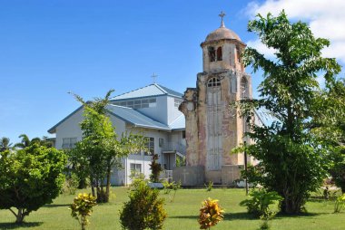 San Jose Katolik Kilisesi 'nin eski çan kulesinin yan görüntüsü. 11. Dünya Savaşı' ndan sonra Tinian, Kuzey Mariana Adaları 'ndaki eski kiliseden geriye kalan tek şey. Yanında da yeni katolik kilisesi..