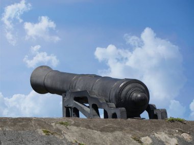 St. Kitts, Batı Hint Adaları 'ndaki Brimstone Hill Kalesi Ulusal Parkı' nda okyanusa doğru yöneltilmiş eski bir topun yan görüntüsü
