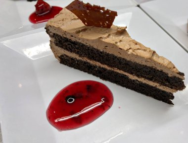 İki katlı kremalı tiramisu keki, üstünde çikolata parçacıklı.