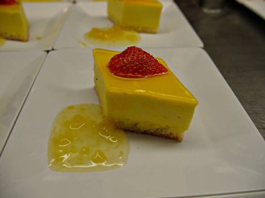 Orta boy limonlu kremalı pasta bir dilim çilekli meyve ve ananas reçeli ile servis edilir.