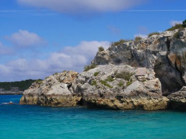 Thunderball Grotto 'yu Exuma Cays, Bahamalar' ın mavi sularında saklayan kaya yığınları. Bu mekan popüler bir yerdir ve birkaç film çekmek için kullanılmıştır..