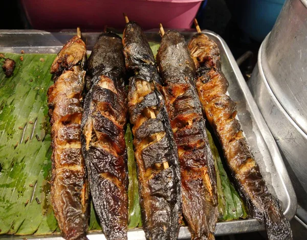 チェンマイの屋台街の夜市で売られているバナナの葉の上に並ぶ焼き魚 — ストック写真