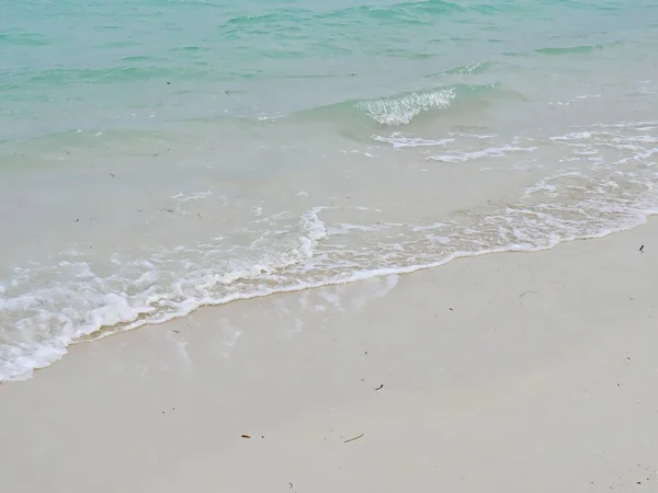 柔和的海浪轻柔地冲刷着海岸 在热带海滩的沙滩上形成迷人的图案 — 图库照片