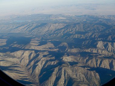 Arizona 'nın göz kamaştırıcı manzarası sabahın erken saatlerinde gölgeli bir uçak penceresi tarafından çerçevelenmiş.