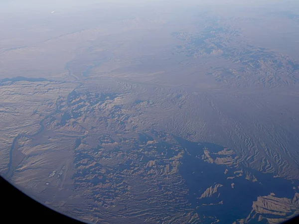 Wide aerial view of the terrains of Arizona landscape,seen from an airplane window.