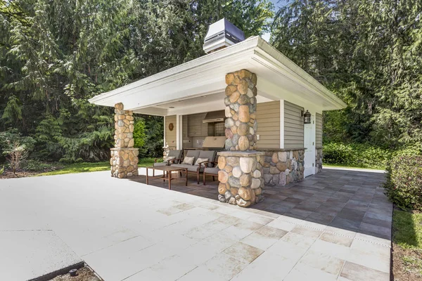 Chic outdoor kitchen space with stone columns and tile flooring