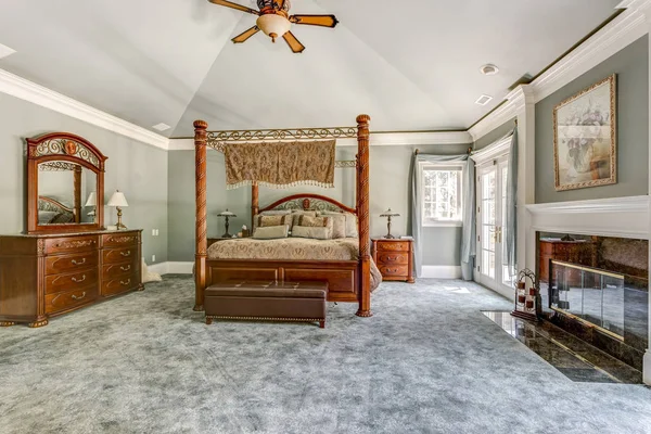 Luxury master bedroom with canopy bed and fireplace