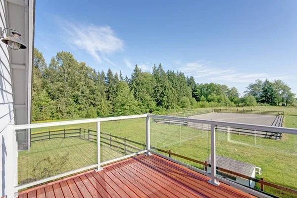 Balcony interior with picturesque view of the backyard on a sunny day.