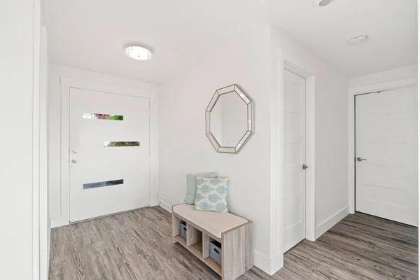 Beautiful white hallway interior with grey hardwood floors in a freshly renovated house.