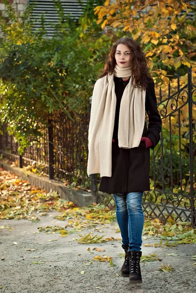 Mulher em um casaco caminha no parque de outono — Fotografia de Stock