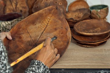 Kız seramik boyar. El yapımı ürünleri ev atölye masada. Çizimler ve desenler ile seramik ürünler.