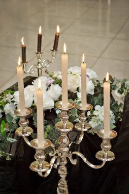 Beyaz güller ve diğer çiçek buketleri restoranda şenlikli bir tablo ile dekore edilmiştir. Masanın üzerine mumlar