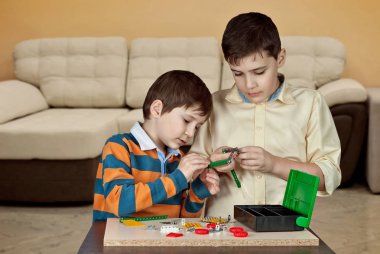 İki erkek bir tasarımcı tarafından masaya oynanır. İki kardeş bir metal Tasarımcısı somunlar ile yapmak.