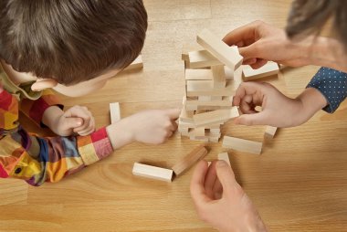 Alt katta Tasarımcısı tarafından oynanır. Eller yakın çekim yapı ahşap kule.