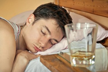 Boş bardak viski ön planda için. Sarhoş adam içinde belgili tanımlık geçmiş. 