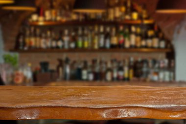 Mockup. Bulanık bar içinde belgili tanımlık geçmiş. Ön planda bir ahşap tahta.