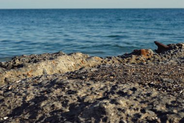 Denizin kayalık kıyısı. Sahilde dalgalar. Mavi deniz suyu.