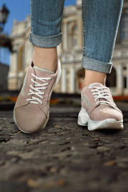 Spor ayakkabılar asfaltta yakın çekim. Alt açıdan bacaklar ve ayakkabılar.