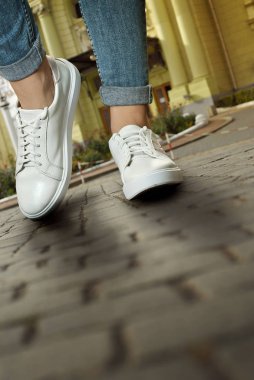 Spor ayakkabılar asfaltta yakın çekim. Alt açıdan bacaklar ve ayakkabılar.