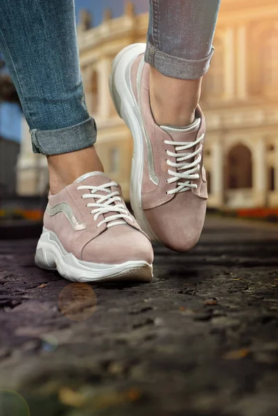 Spor ayakkabılar asfaltta yakın çekim. Alt açıdan bacaklar ve ayakkabılar.