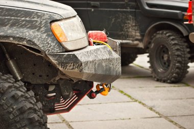 Tekerlekler, ışıklar ve tamponlar bataklıkta bağlı. Cipin kirli parçaları. Yakın plan..