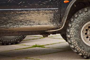 Tekerlekler, ışıklar ve tamponlar bataklıkta bağlı. Cipin kirli parçaları. Yakın plan..