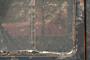 Eski bir arabanın kapısındaki kir. Metal bir yakın çekimde toprak ve toz dokusu. Siyah arkaplana düşer ve sıçrar.