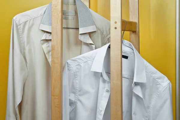 Clean and dirty shirt together. Two white shirts in one shot. The concept of washing and bleaching clothes. The contrast between the new and the old shirt.