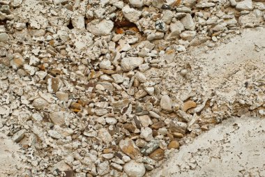 Çakıl lı beton duvar. Evin gri temeli. Duvardaki pas parçaları.