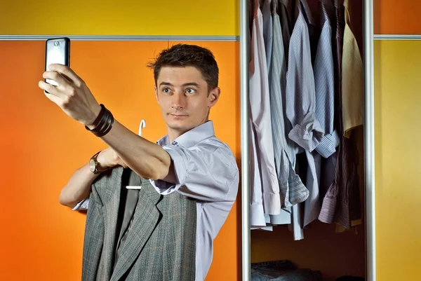 Мужчина Полосатой Рубашке Примеряет Одежду Заднем Плане Шкафа Желтый Оранжевый — стоковое фото
