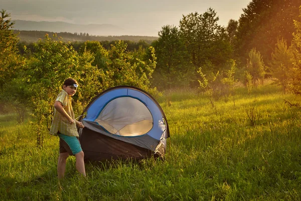 Tipo Pôs Uma Tenda Relva Floresta Montanhas Fundo Sol Entra — Fotografia de Stock