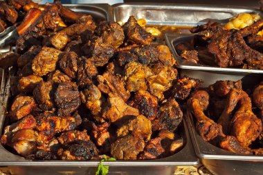 Kömürlerde barbekü kızartması. Tarla mutfağı festivalinde et ve sığır eti. Masada demir tepside kızarmış et.