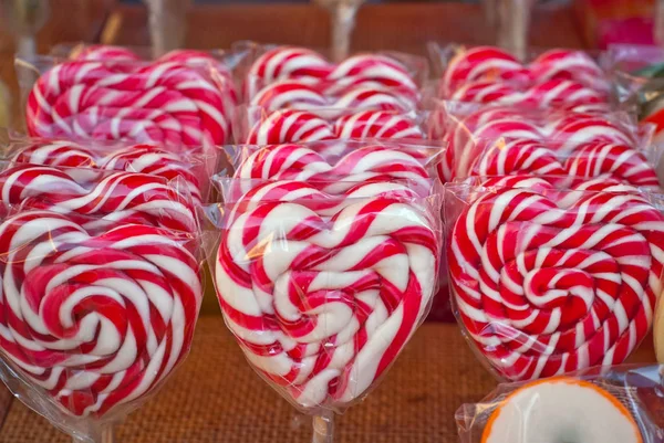 Many colorful lollipops on a stick. Sweets are sold at the city fair.