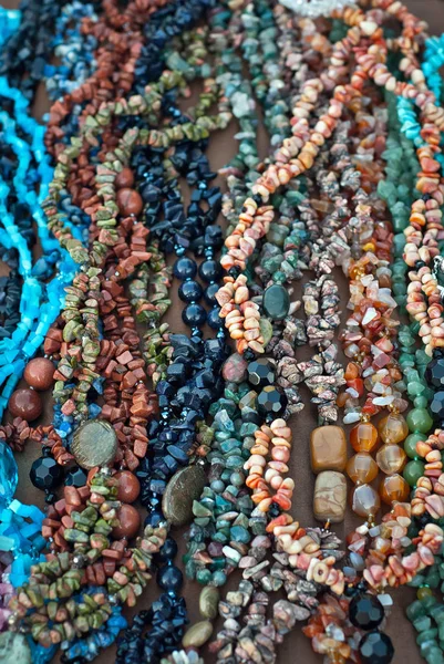 桌上摆着五颜六色的石头项链 许多不同的珠宝和珠子由天然珍贵矿物制成 琥珀首饰在展会上出售 — 图库照片