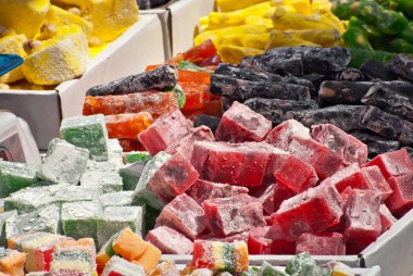 Fuarda Türk ulusal tatlıları satılıyor. Masaya yığılmış çok renkli Asya tatlıları. Festivalde lokum toptan satılıyor..