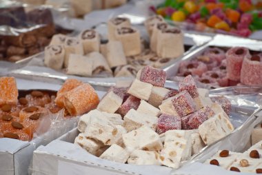 Fuarda Türk ulusal tatlıları satılıyor. Masaya yığılmış çok renkli Asya tatlıları. Festivalde lokum toptan satılıyor..