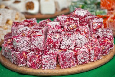 Fuarda Türk ulusal tatlıları satılıyor. Masaya yığılmış çok renkli Asya tatlıları. Festivalde lokum toptan satılıyor..