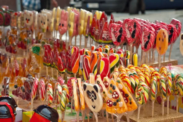 Many colorful lollipops on a stick. Sweets are sold at the city fair.
