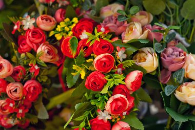 Panayırda yapay çiçek buketleri satılıyor. Renkli küçük çiçeklerden yapılmış korolalar. Ulusal dekorasyon ve giysi aksesuarlarının kapatılması.