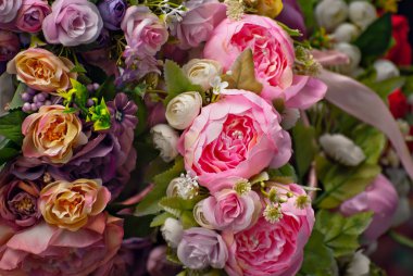 Panayırda yapay çiçek buketleri satılıyor. Renkli küçük çiçeklerden yapılmış korolalar. Ulusal dekorasyon ve giysi aksesuarlarının kapatılması.