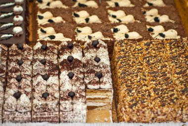 Bir dükkan penceresinde kırmızı doldurulmuş yuvarlak pasta. Pastanın üzerine marshmallow. Kek parçalara ayrılmış.