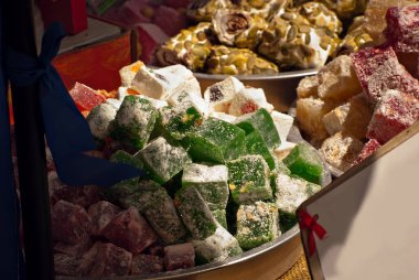 Fuarda Türk ulusal tatlıları satılıyor. Masaya yığılmış çok renkli Asya tatlıları. Festivalde lokum toptan satılıyor..