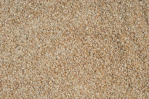 Buğday dokusu. Tahta bir masada ezilmiş buğday taneleri. Eski bir kontrplak tahtaya dağılmış öğütülmüş tahıllar.