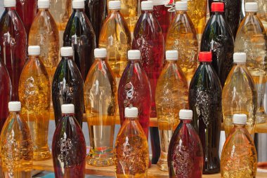 Fuarda çeşitli şişe alkollü içecekler satılmaktadır. Ev yapımı otlar üzerinde tentürler. Rafta kavanozlarda doğal içecekler.