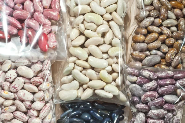 Many beans are sorted by type and packaged in transparent packages. Different types of beans are prepared for sale. Grains for seedling.