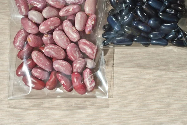 Many beans are sorted by type and packaged in transparent packages. Different types of beans are prepared for sale. Grains for seedling.