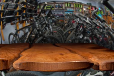 Modelleme. Bisikletli spor mağazası görüntüsü. Odaklanamayan, bulanık görüntü. Ön planda ahşap bir masanın üstü, tezgah..