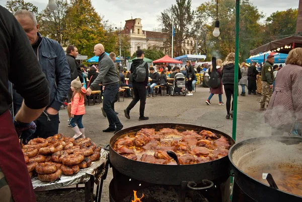 Ukrayna, Chernivtsi. 5-6 Ekim 2019. Şehir Festivali. Kömürde ızgara kızartma. Bulanık insanlar arka plandaki masada yemek yerler. Mutfak festivalinde et ve et.