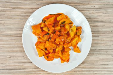 Tahta bir masada beyaz bir tabakta patates. Portakal soslu haşlanmış patates. Yazı için plakaya yakın bir yere. Tasarım için alanı kopyala.