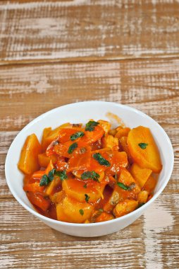 Tahta bir masada, beyaz bir kasede patates. Pembe bir tahtanın üzerinde portakal soslu haşlanmış patates. Yazı için plakaya yakın bir yere. Tasarım için alanı kopyala.